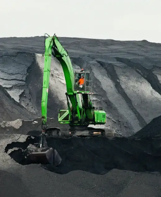 Drill crew working a rig underground, lit by machine floodlights
